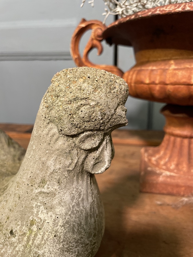 Old statue of a chicken with wear
