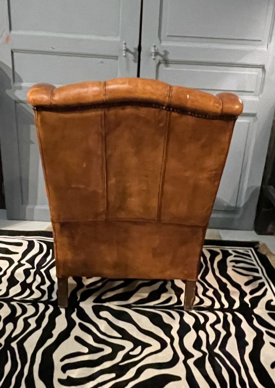 Bijna antieke leren oorfauteuil met leuke details