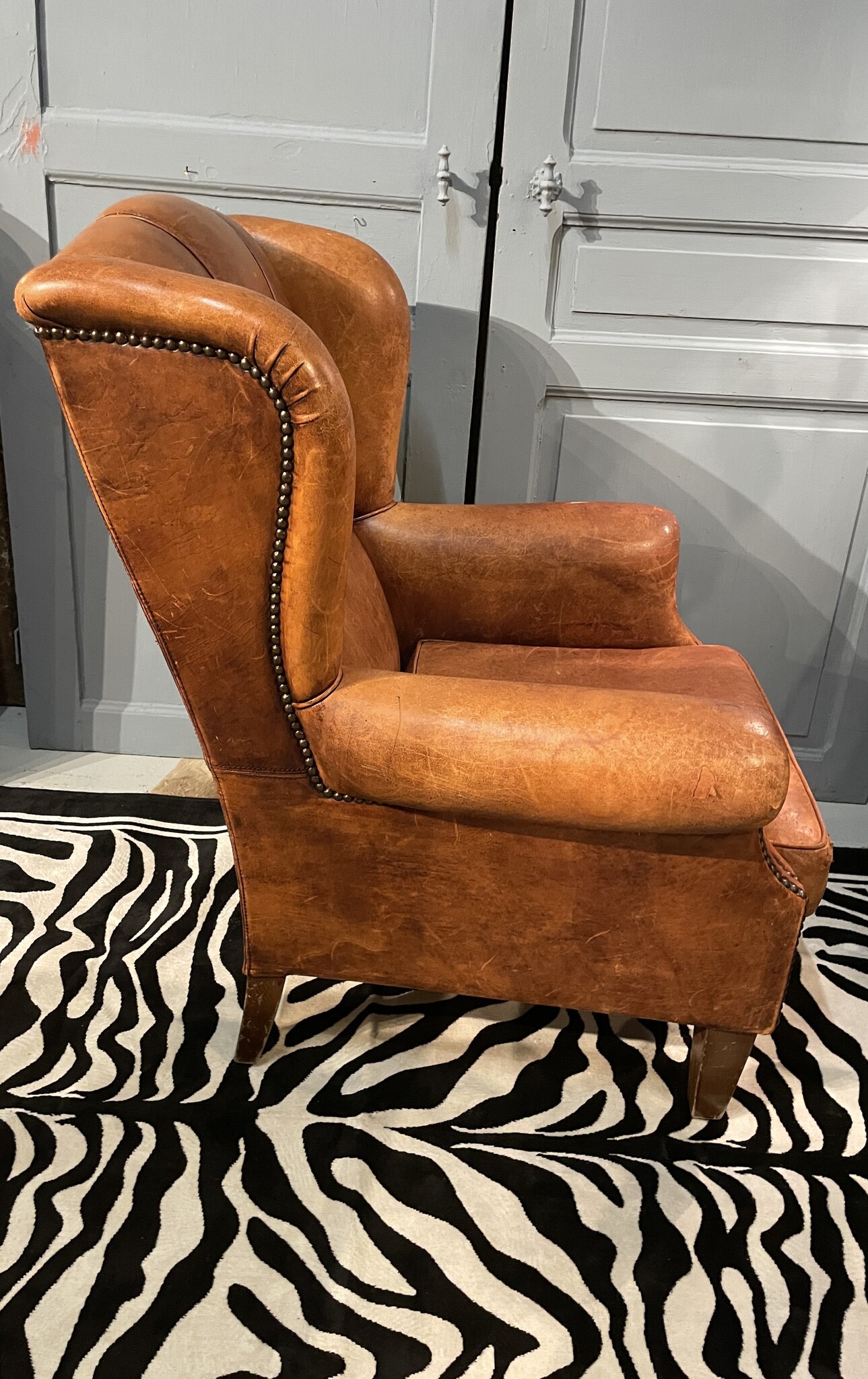 Almost antique leather wingback armchair with charming details