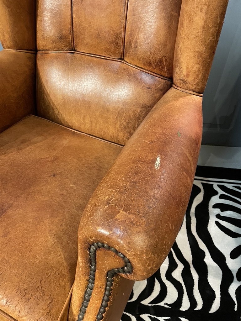 Bijna antieke leren oorfauteuil met leuke details