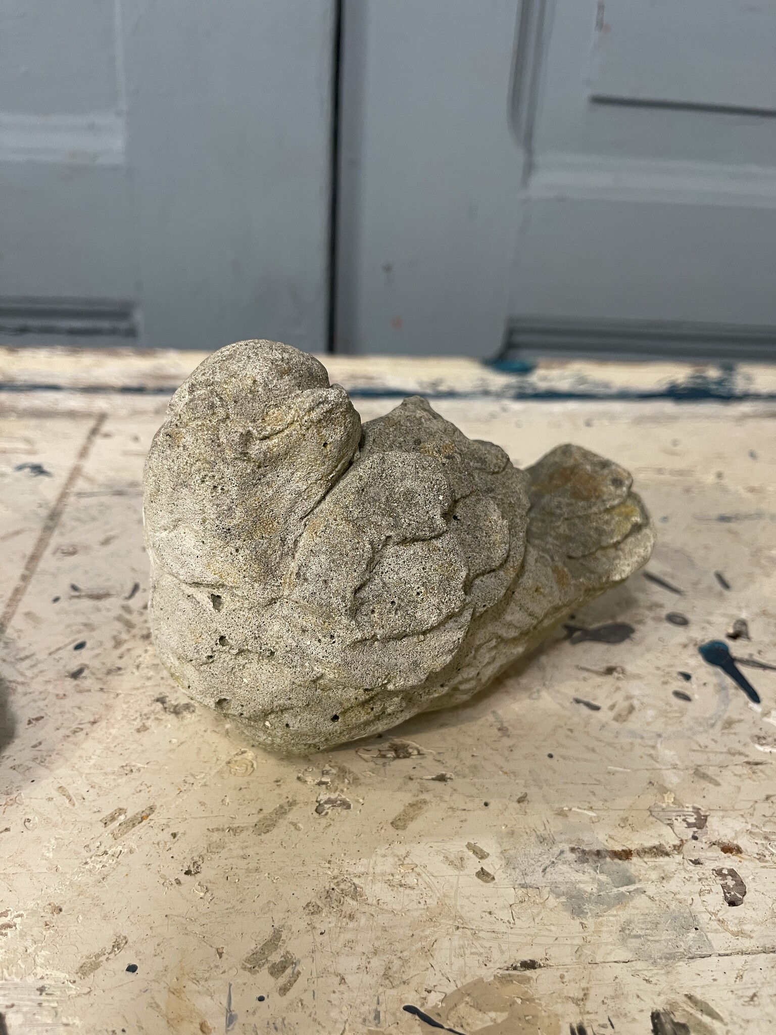 Pair of cement birds with a smile on their face