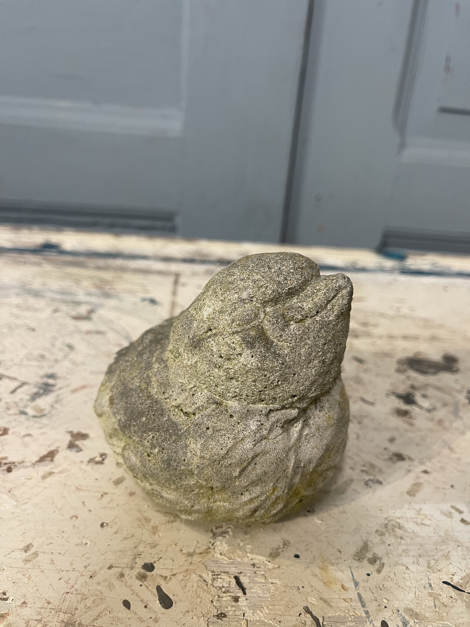 Pair of cement birds with a smile on their face