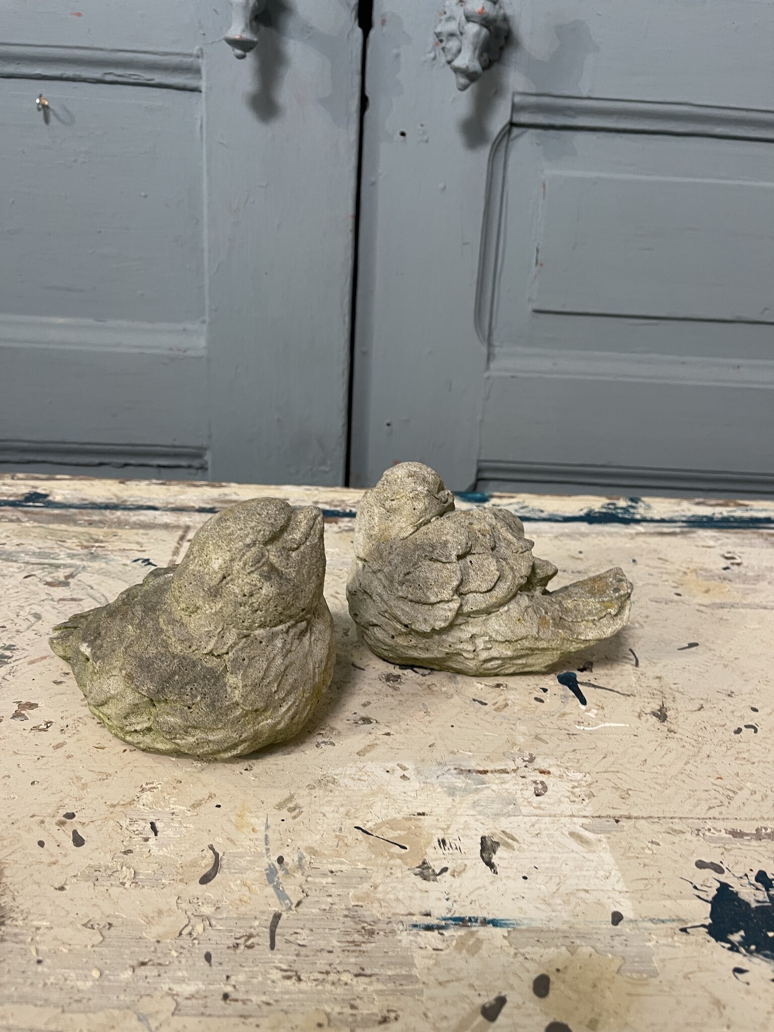Stel betonnen vogeltjes met een grijns op hun bekkie