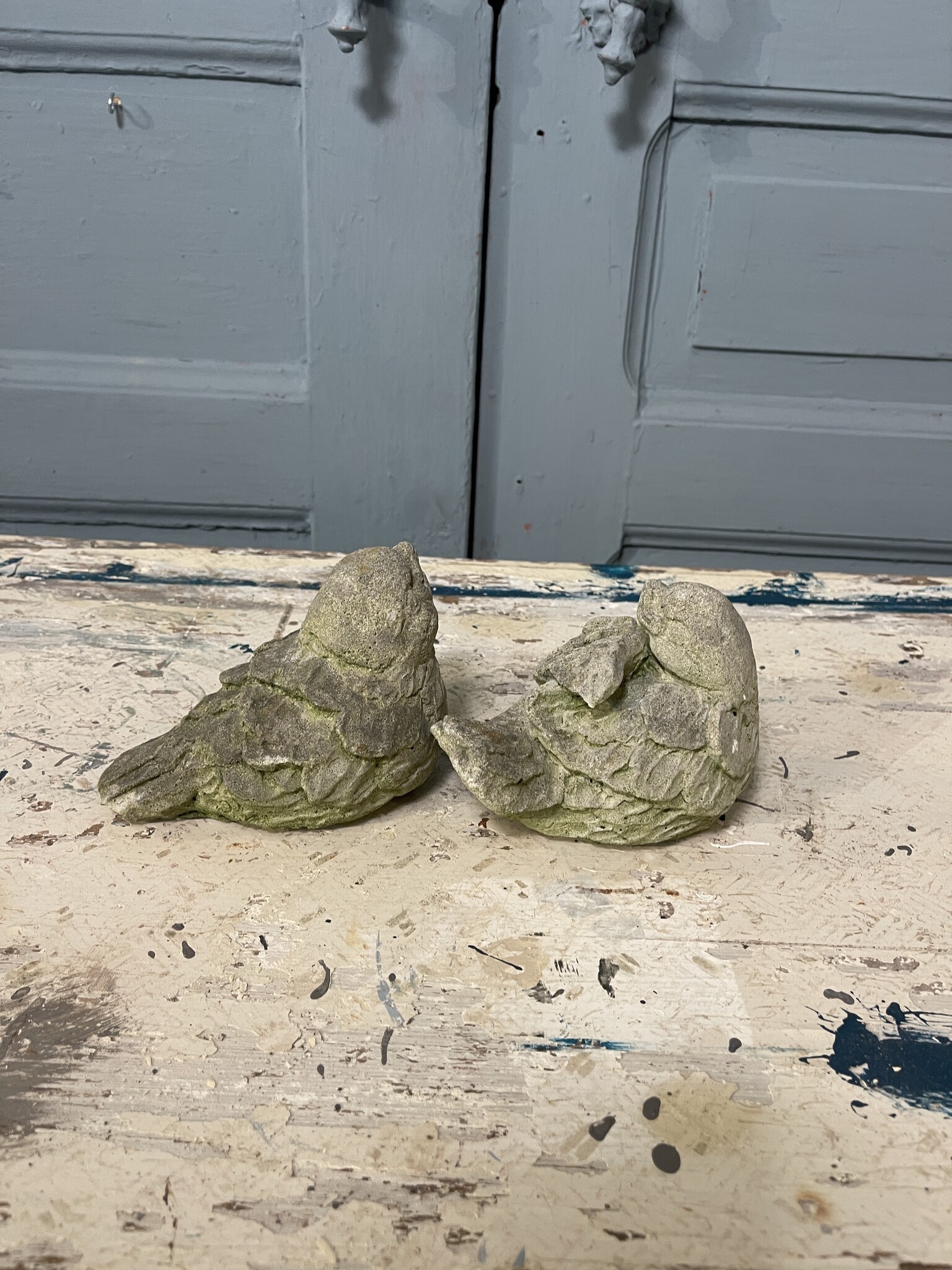 Stel betonnen vogeltjes met een grijns op hun bekkie