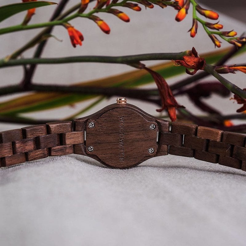 El reloj Viola de la Colección FLORA debe su nombre a la flor viola negra dado que es única. La madera natural de nogal ha sido trabajada finamente a mano para lograr su delgadez. La esfera Viola está hecha de acero inoxidable en color negro con un toque