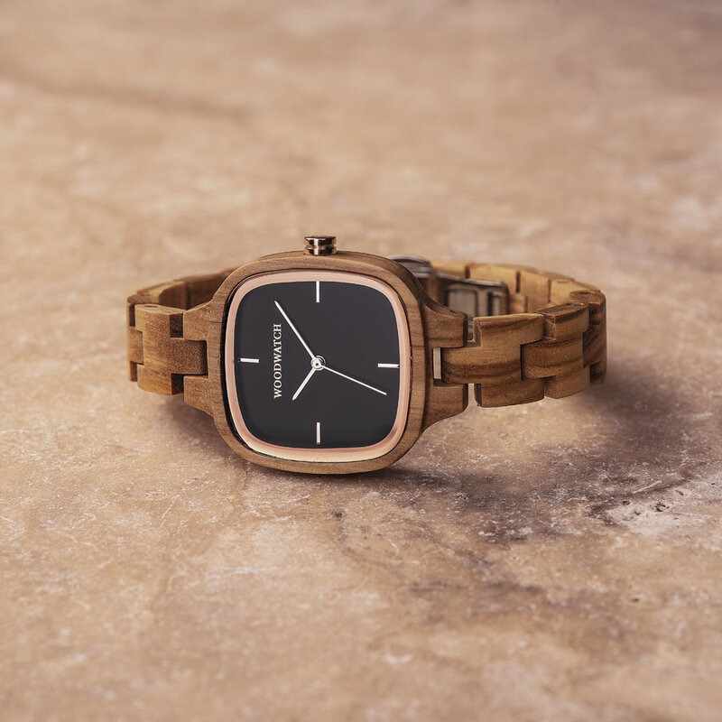 Un icono de moda duradero. El CITY Icon presenta una caja cuadrada con una esfera negra y detalles en oro rosa. La correa del reloj está hecha de madera de olivo que ha sido perfectamente acabada a mano para crear nuestro más reciente diseño en correa del