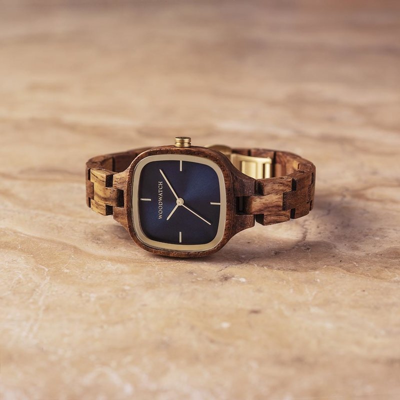 El Starlight cuenta con caja cuadrada de 30 mm, con esfera azul marino los detalles son dorados. La pulsera del reloj es de madera de kosso natural sometida a un perfecto acabado manual para ofrecer nuestro último diseño de pulseras pequeñas.