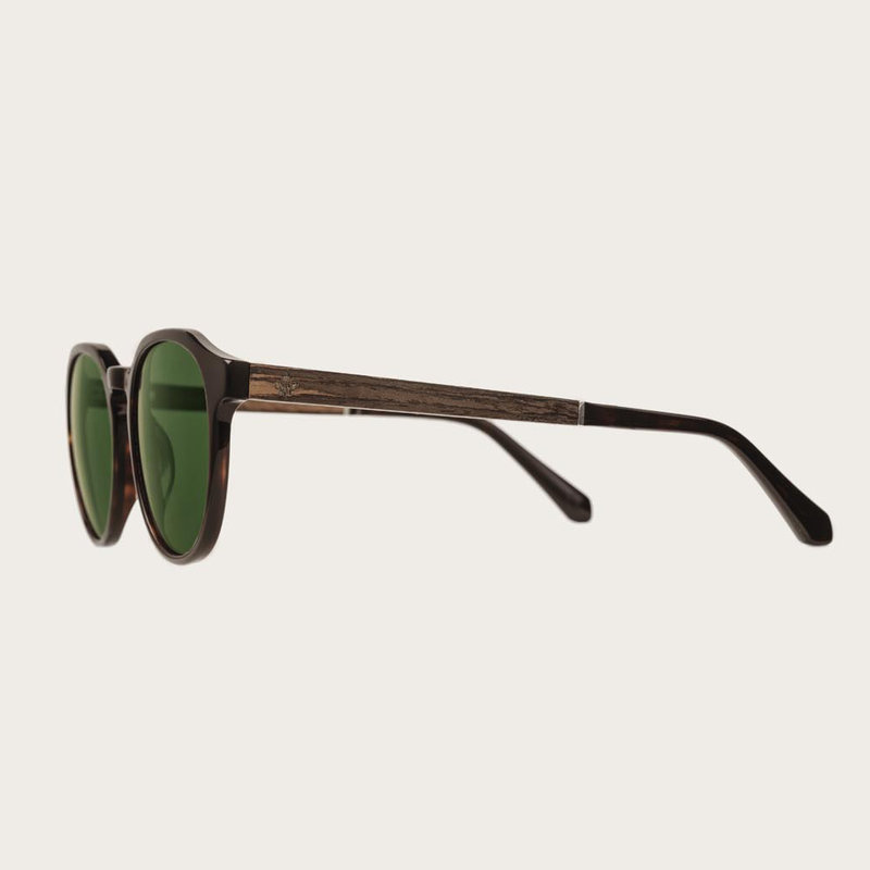 La paire de lunettes le REVELER Forever Havanas Camo poséde un cadre élégant marron foncé en écaille de tortue en camouflage vert.  Fabriquée à partir de bois durable et du bioacétate Mazzuchelli Italien avec des branches et écaille de tortue en ébène et