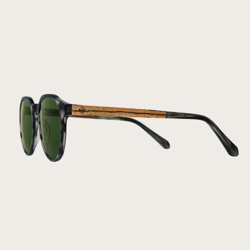 The REVELER Heritage Camo features a sleek geometric grey tortoise frame with green camo lenses. Composed of durable Italian Mazzucchelli bio-acetate with hand-finished natural zebrawood temples and tortoise acetate tips. Bio-acetate is made from cotton a