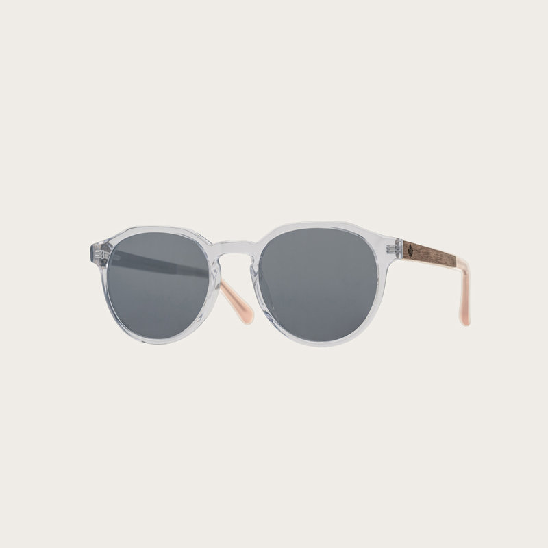 The REVELER Clear Smoke features a sleek geometric clear frame with grey smoke lenses Composed of durable Italian Mazzucchelli bio-acetate with hand-finished natural senna siamea wood temples and nude acetate tips. Bio-acetate is made from cotton and orga