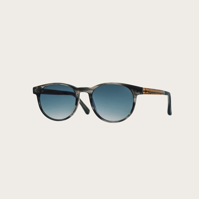 ELLIPSE Heritage Gradient Blue har en karakteristiskt avrundad grå sköldpaddsmöntrad båge med gradientblå linser. Gjorda av hållbart italienskt Mazzucchelli bio-acetat med handbehandlade naturliga skalmar av zebraträ temples och sköldpaddsmönstrade ändar