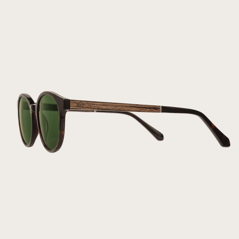La paire de lunettes, le SOHO Forever Havans Camo poséde une forme ovale avec un cadre en écaille de tortue marron foncé avec des verres en camouflage vert. Fabriquée à partir de bois durable et du bioacétate Mazzuchelli Italien avec des branches et écail