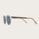 La paire de lunettes le SOHO Clear Smoke poséde un cadre ovale claire avec des verres en gris fumé et fabriquée à partir de bois durable et du bioacétate Mazzuchelli Italien avec des branches de senna siamea naturel en bois et des manchons en acétate nude