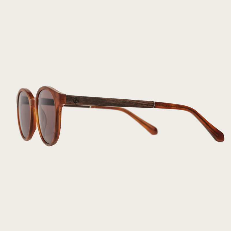 La paire de lunettes le SOHO Classic Havanas Brown poséde un cadre ovale en jaune foncé avec des verres en brun moka. Fabriquée à partir de bois durable et du bioacétate Mazzuchelli Italien avec des branches et écaille de tortue en ébène et manchons en ac