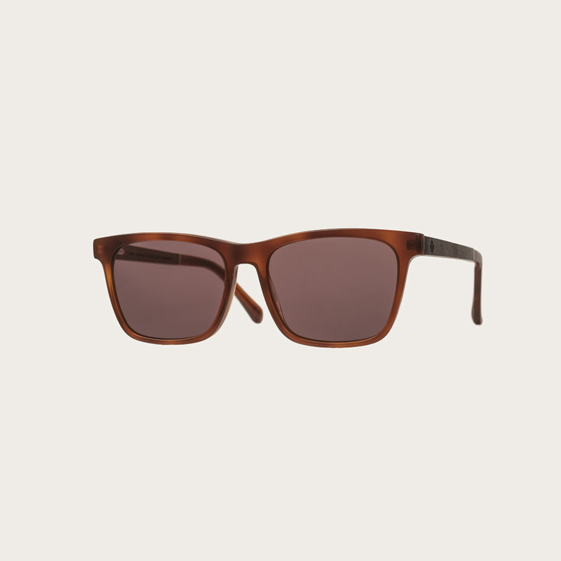 La paire de lunettes, BROOKLYN Classic Havans Brown poséde un cadre carré en écaille de tortue jaune foncé avec des verres bruns moka. Fabriquée à partir de bois durable et du bioacétate Mazzuchelli Italien avec des branches et écaille de tortue en ébène