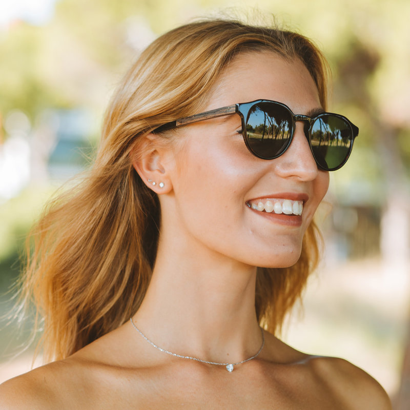 La paire de lunettes le REVELER Black Camo poséde un cadre élégant noir avec des verres en camouflage vert.  Fabriquée à partir de bois durable et du bioacétate Mazzuchelli Italien avec des branches et écaille de tortue en bois de rose et des manchons en