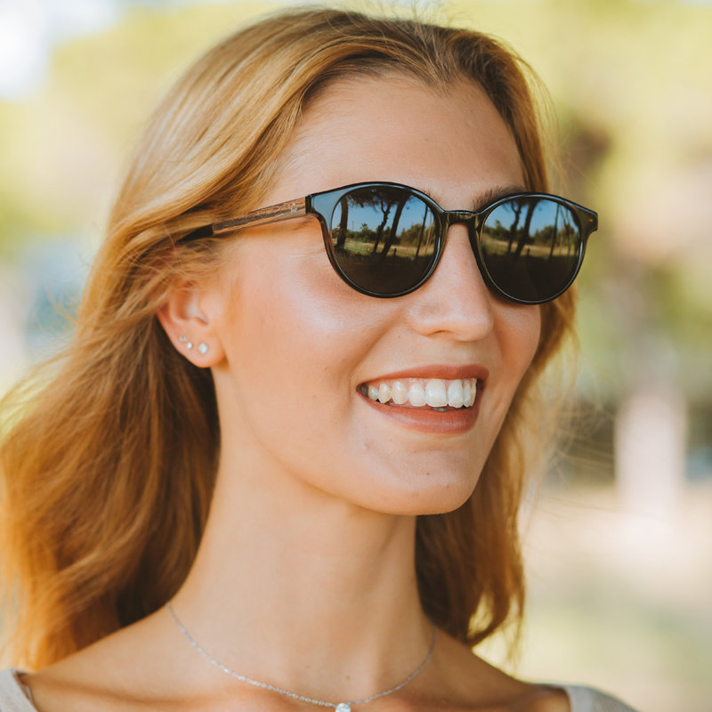 La paire de lunettes le SOHO Forever Havanas Black poséde un cadre ovale en marron foncé avec des verres en noir. Fabriquée à partir de bois durable et du bioacétate Mazzuchelli Italien avec des branches et écaille de tortue en ébène et manchons en acétat