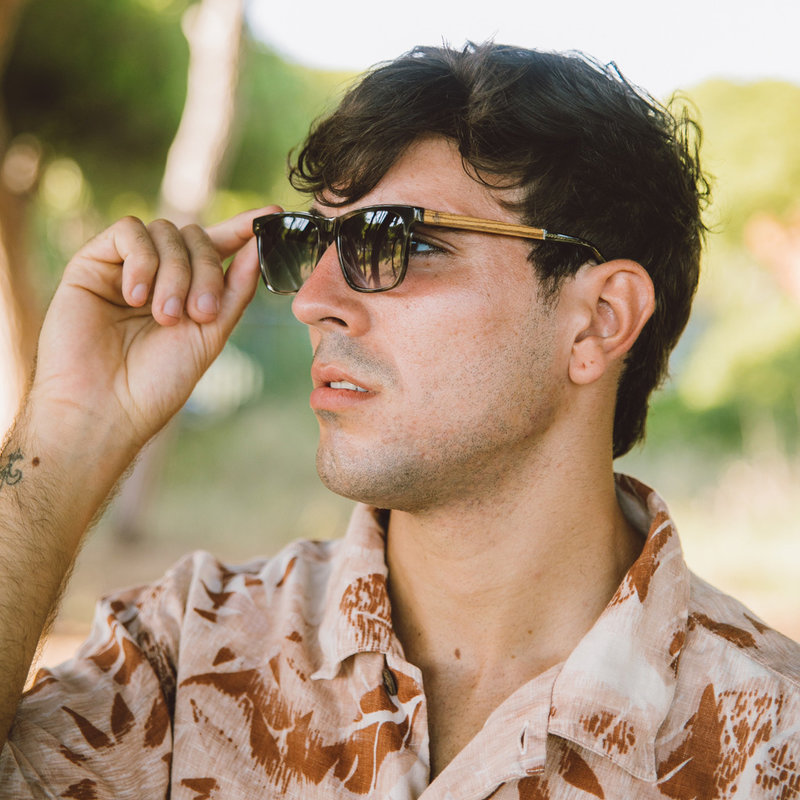 La paire de lunettes BROOKLYN Heritage Camo poséde un cadre carré en écaille gris avec des verres en camouflage vert. Fabriquée à partir de bois durable et du bioacétate Mazzuchelli Italien avec des branches de bois zèbre naturel et des manchons en acétat