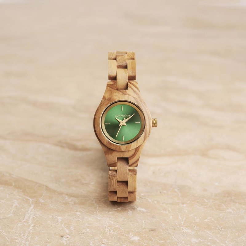 El reloj Dahlia de la Colección FLORA está formado por madera de olivoa que ha sido formada a mano hasta su más fina esbeltez. El Dahlia cuenta con una esfera verde con detalles de colores dorados.