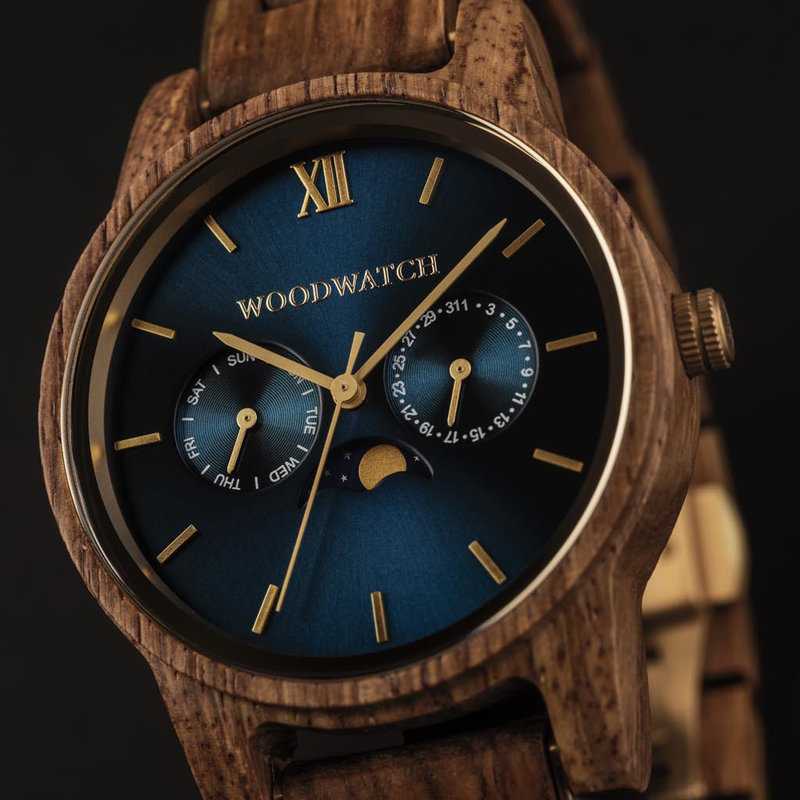 The men's CLASSIC Sailor watch has a classy slim case while featuring a unique moonphase movement and two extra subdials. The watch is made of East African Kosso Wood and features a blue dial and golden-colored details, perfectly matching the AURORA Ocean