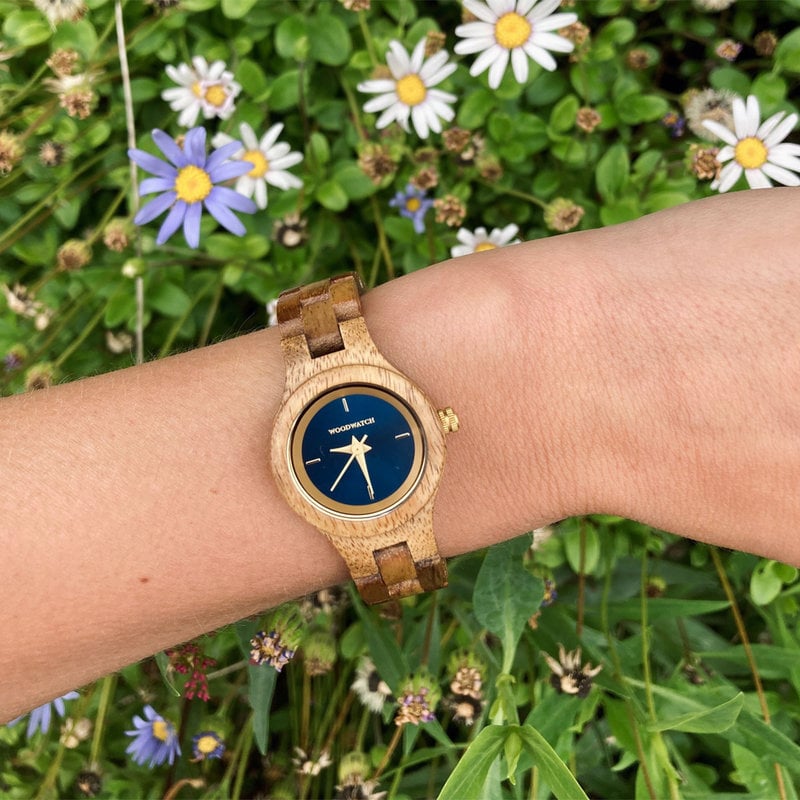 The Bellflower watch from the FLORA Collection consists of acacia wood that has been hand-crafted to its finest slenderness. The Bellflower features a dark navy blue dial with golden coloured details.