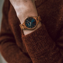 La Collection AURORA est inspirée par l'air et les paysages de la nature Scandinave. Cette montre légère fabriquée avec du bois Kosso d'Afrique de l'Est dispose d’un cadran bleu en acier inoxydable orné de détails en or rose. Le bracelet est disponible en