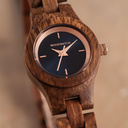 La montre Delphine de la collection FLORA est composée de bois lisse kosso finement travaillé à la main. Le modèle Delphine comporte un cadran bleu marine foncé avec des détails colorés or rose.