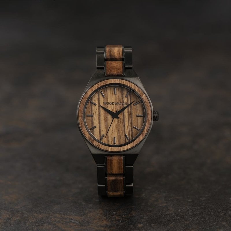 L'UNITY Ash est une montre élégante qui combine deux éléments puissants, créant ainsi un design classique qui lui est propre. La montre comporte un bracelet gris en acier inoxydable ainsi qu'un boîtier de 38 mm présentant les caractéristiques du bois qui