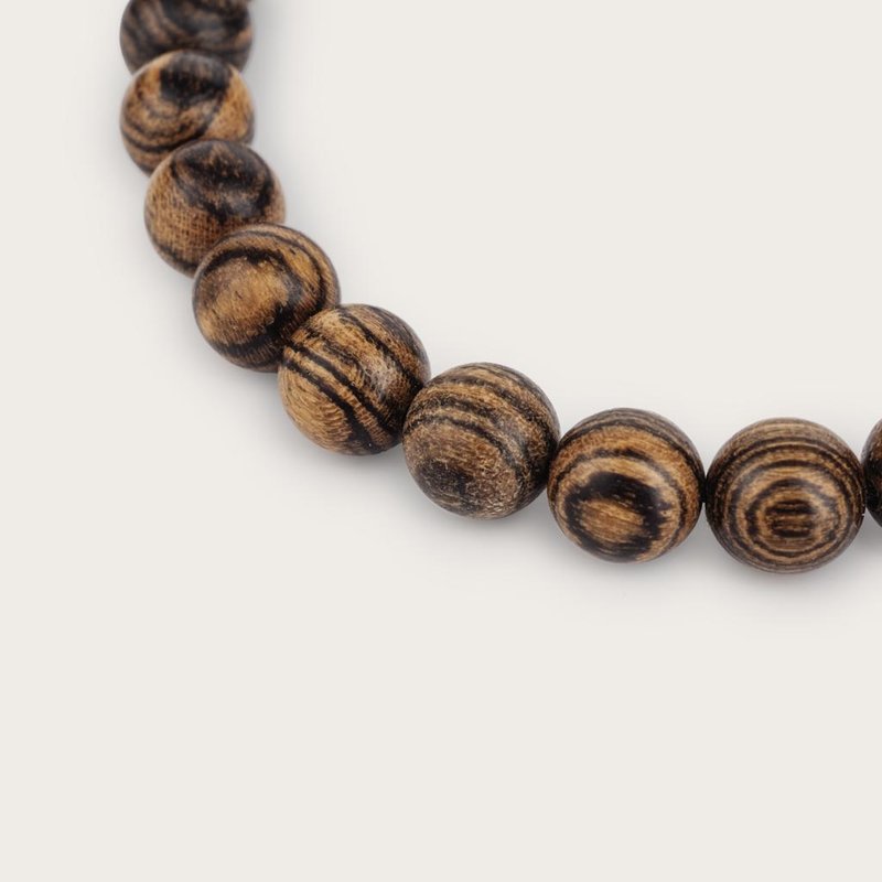 Bei unserem handgefertigten Zebrano Armband werden Perlen aus Wengeholz durch Lavasteinperlen ergänzt. Vervollkommne deinen WoodWatch-Look mit diesem stylischen Armband. Die Perlen haben einen Durchmesser von 8 mm und das Armband ist größenverstellbar, so