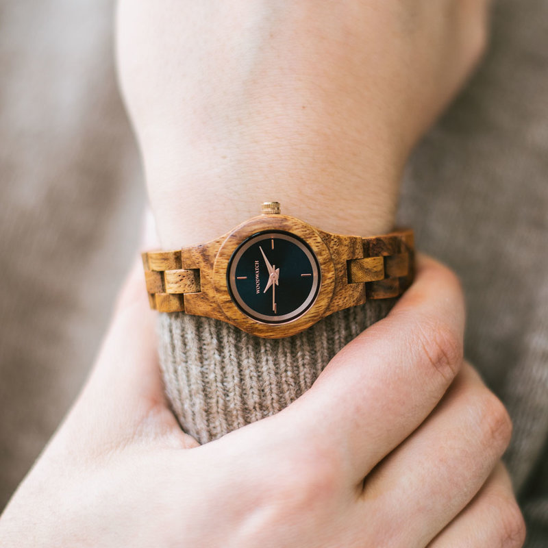 L’orologio Delphine della collezione FLORA è realizzato in legno di kosso morbido lavorato a mano per renderlo il più sottile possibile. Delphine è dotato di un quadrante blu navy scuro con dettagli oro rosa.