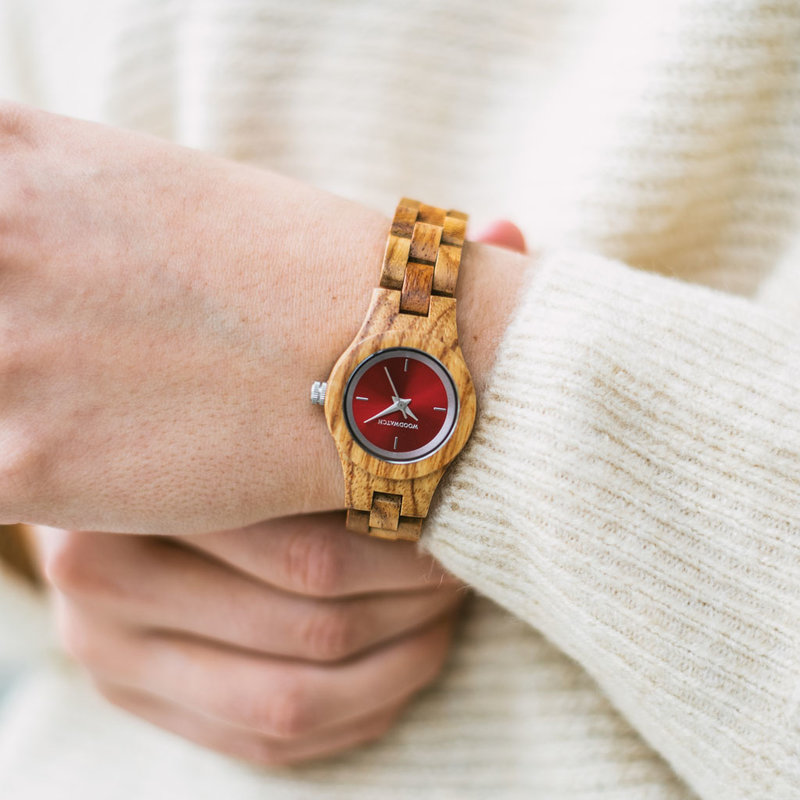 Het Poppy horloge uit de FLORA Collection bestaat uit zacht kosso hout dat met de is hand bewerkt tot een verfijnd uurwerk. De Poppy is voorzien van een rood wijzerplaat met zilveren accenten.