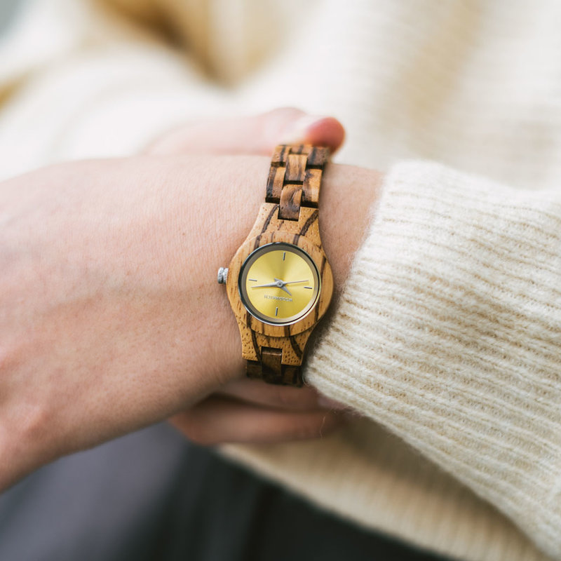 Het Senna horloge uit de FLORA Collection bestaat uit zacht zebrahout dat met de is hand bewerkt tot een verfijnd uurwerk. De Senna is voorzien van een Geel wijzerplaat met zilveren accenten.