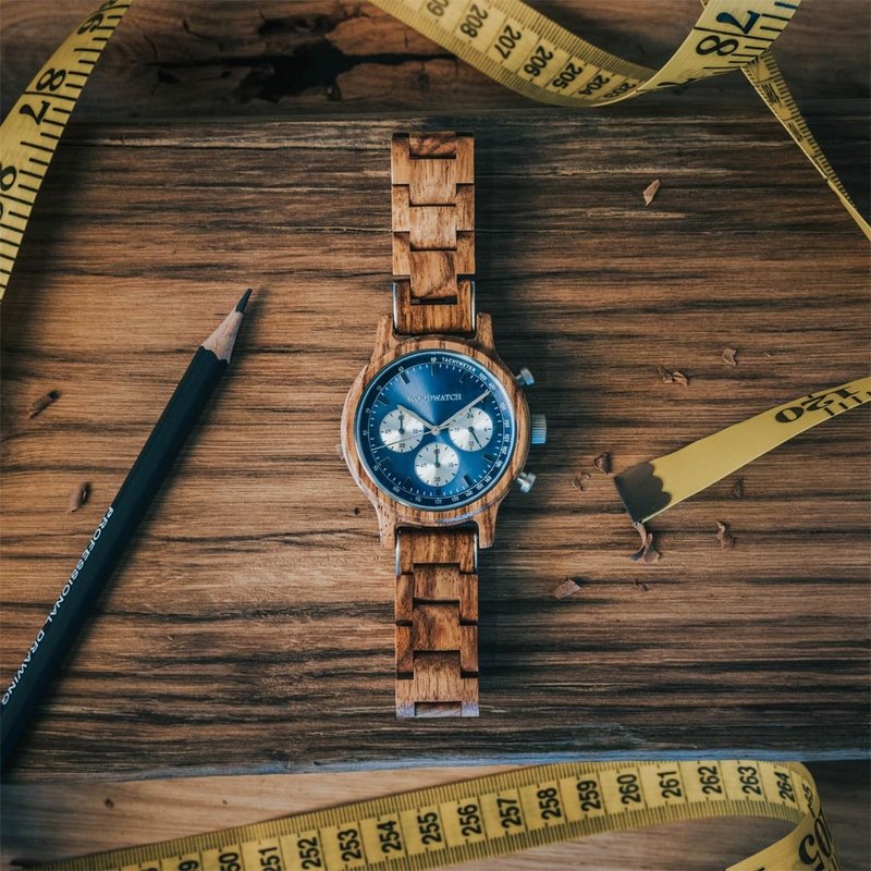 La Chrono Mariner Kosso est fabriquée à partir de bois de kosso et présente un cadran bleu à double couche avec des détails argentés.