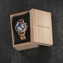 La Chrono Mariner Kosso est fabriquée à partir de bois de kosso et présente un cadran bleu à double couche avec des détails argentés.