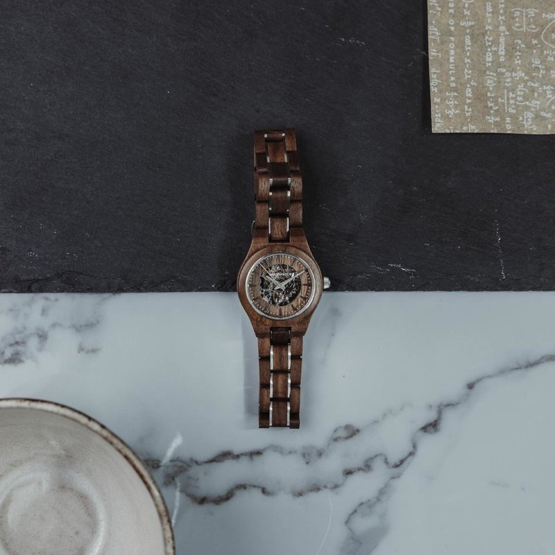 The AUTOMATIC Voyager features a self-winding automatic mechanical movement with 36 hours power reserve. A distinctive optical experience is created through the 33mm case with a silver bezel and partial wooden dial with an open heart, revealing the comple