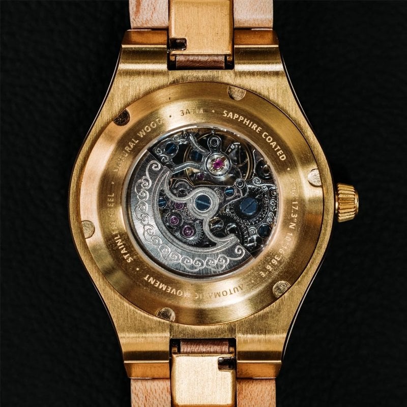 The AUTOMATIC Nomad features a self-winding automatic mechanical movement with 36 hours power reserve. A distinctive optical experience is created through the 33mm case with a gold bezel and partial wooden dial with an open heart, revealing the complexity