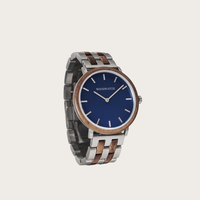 Un design MINIMAL repensé avec un look intemporel qui s'adapte à toutes les occasions. La montre est dotée d'un boîtier fin en acier, d'une lunette en noyer et d'un cadran bleu. Elle est livrée avec un nouveau bracelet de montre, conçu dès le départ pour