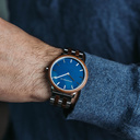 Een nieuw MINIMAL design met een tijdloze uitstraling die past bij elke gelegenheid. Het horloge heeft een slanke, stalen kast, lunette van walnoothout en blauwe wijzerplaat. Wordt geleverd met een volledig nieuw ontworpen horlogeband, die qua stijl en ma