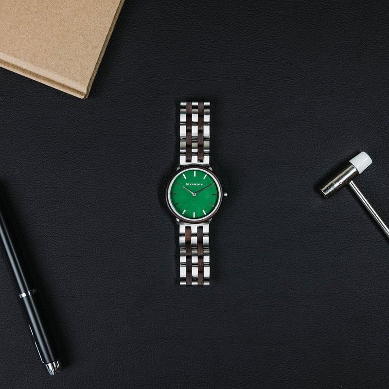 Een nieuw MINIMAL design met een tijdloze uitstraling die past bij elke gelegenheid. Het horloge heeft een slanke, stalen kast, lunette van loodhout en groene wijzerplaat. Wordt geleverd met een volledig nieuw ontworpen horlogeband, die qua stijl en mater