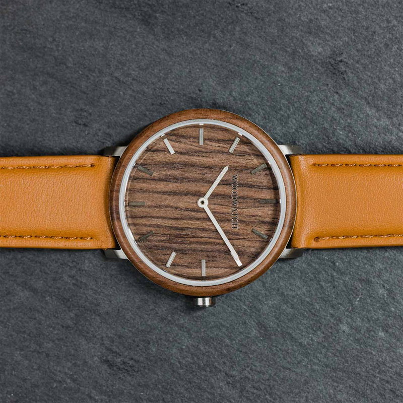 Un design MINIMAL repensé avec un look intemporel qui s'adapte à toutes les occasions. La montre est dotée d'un boîtier mince en acier, d'une lunette en bois de noyer et d'un cadran. Elle est livrée avec un nouveau bracelet de montre, conçu dès le départ