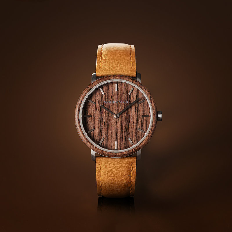 Een nieuw MINIMAL design met een tijdloze uitstraling die past bij elke gelegenheid. Het horloge heeft een slanke, stalen kast en zowel een lunette als wijzerplaat van walnoothout. Wordt geleverd met een volledig nieuw ontworpen horlogeband, die qua stijl