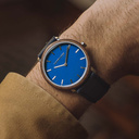 Un design MINIMAL repensé avec un look intemporel qui s'adapte à toutes les occasions. La montre est dotée d'un boîtier fin en acier, d'une lunette en noyer et d'un cadran bleu. Elle est livrée avec un nouveau bracelet de montre, conçu dès le départ pour