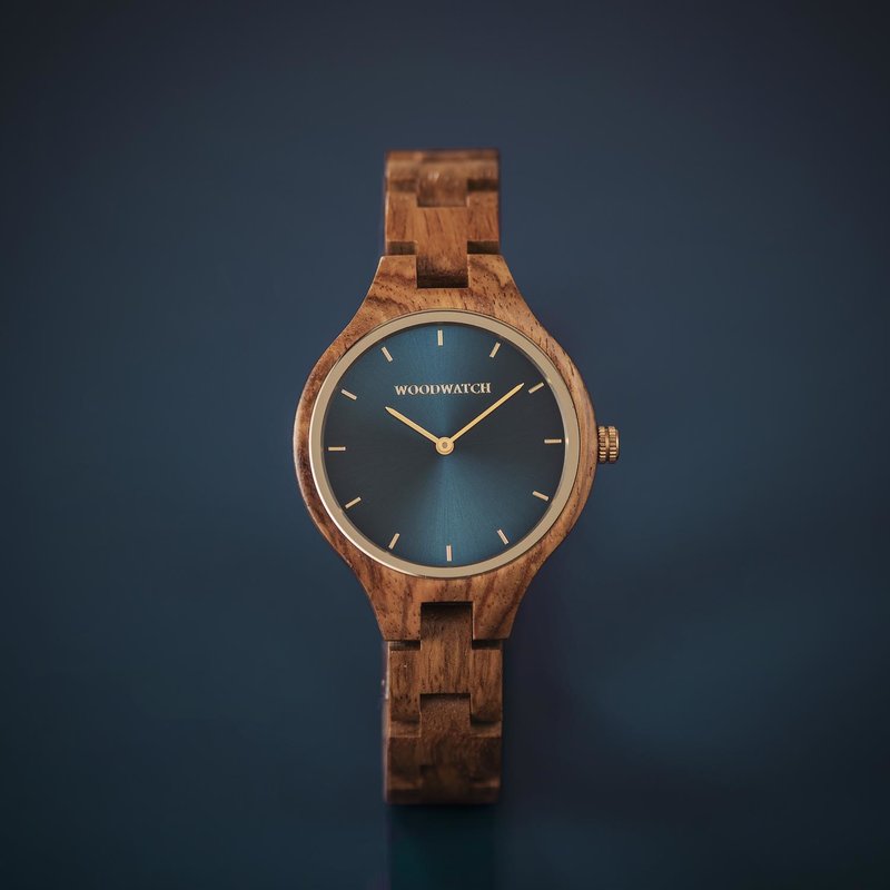 The AURORA Collection breaths the fresh air of Scandinavian nature and the astonishing views of the sky. This light weighing watch is made of kosso wood, accompanied by a blue stainless-steel dial with golden details.<br />
The watch is available with a wooden