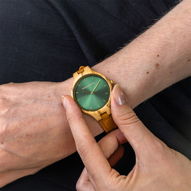 The AURORA Collection breaths the fresh air of Scandinavian nature and the astonishing views of the sky. This light weighing watch is made of olive wood, accompanied by a green stainless-steel dial with golden details.<br />
Comes with a cactus leather strap i