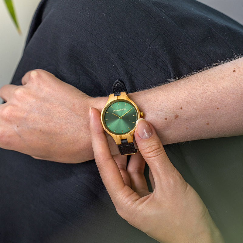 La collezione AURORA ricorda l'aria pura Scandinava e la vista straordinaria del cielo stellato. Questo orologio ultra leggero realizzato in Legno d'ulivo ha un quadrante verde in acciaio inossidabile con dettagli d'oro.<br />
Viene fornito con un cinturino in