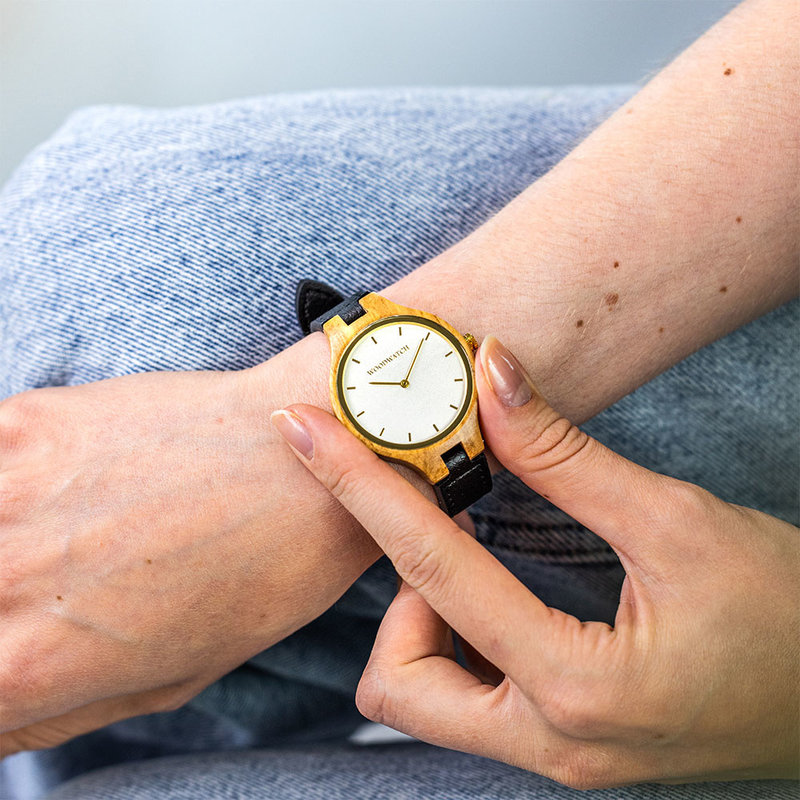 La Collection AURORA est inspirée par l'air et les paysages de la nature Scandinave. Cette montre légère fabriquée avec du bois d'olivier Européen dispose d’un cadran en acier inoxydable orné de détails dorés. Elle est livrée avec un bracelet en cuir de c