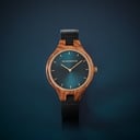 The AURORA Collection breaths the fresh air of Scandinavian nature and the astonishing views of the sky. This light weighing watch is made of kosso wood, accompanied by a blue stainless-steel dial with golden details.<br />
Comes with a cactus leather strap in