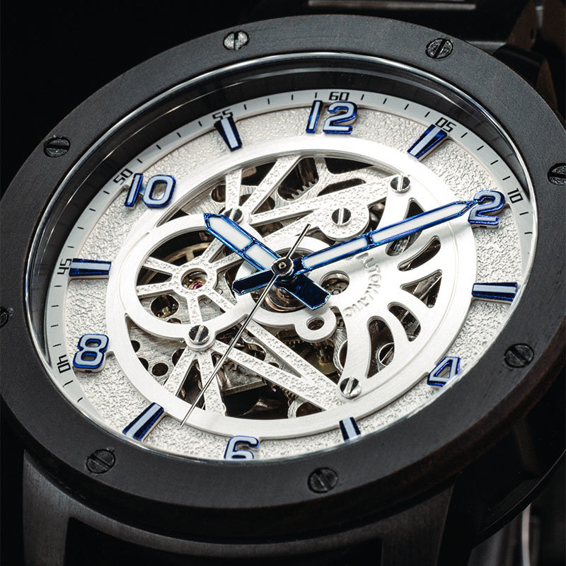 La montre HEROIC Pure Sand est faite en bois de Chacate Preto et présente un cadran blanc avec des détails bleus.