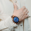 Die CLASSIC Sailor hat ein schlankes und elegantes Gehäuse und verfügt über eine einzigartige Mondphasenanzeige und zwei zusätzliche Hilfszifferblätter. Die aus ostafrikanischem Kosso-Holz gefertigte Uhr hat ein blaues Zifferblatt und goldene Details. Die