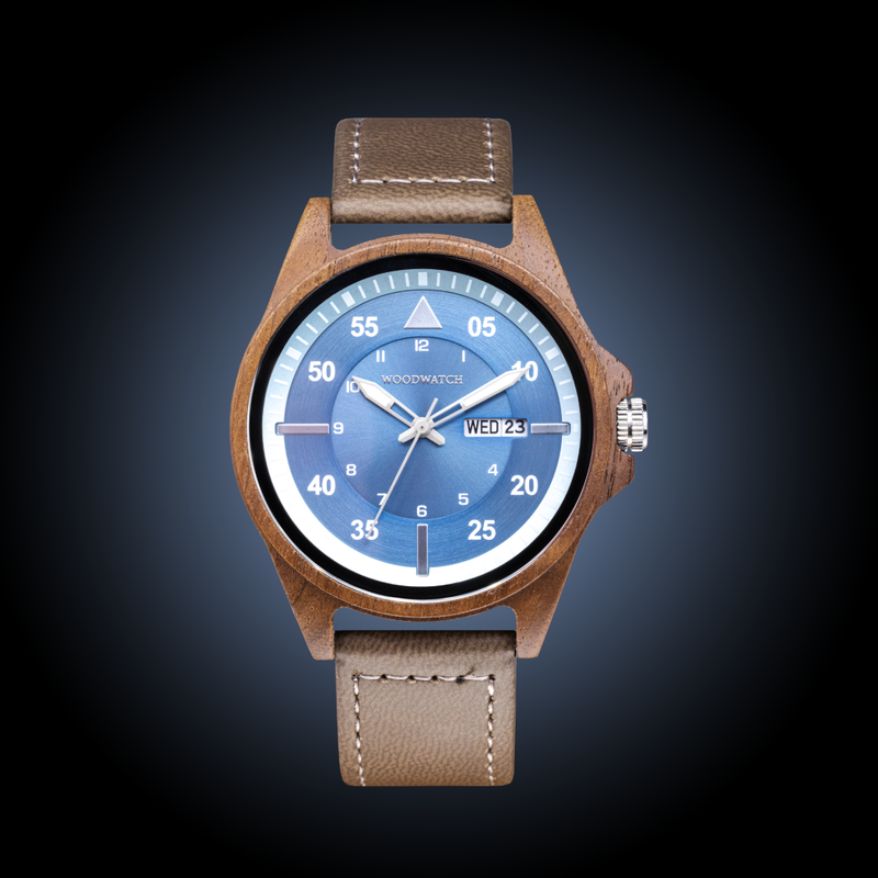 Eminent Prime è realizzato in legno di noce, con quadrante blu, cinturino vegano grigio e dettagli in metallo argentato.